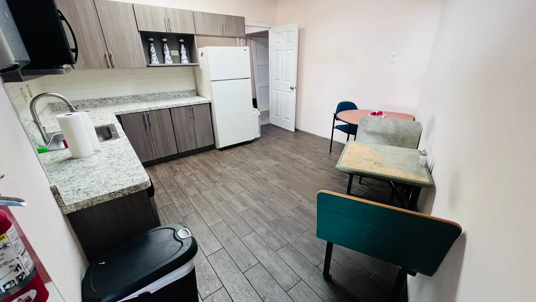 EMP Country Club guest kitchen with refrigerator, sink, counter space, and seating