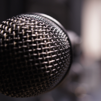 Close up photo of a dynamic microphone in one of our rehearsal studios, the background blurred out for artistic effect.