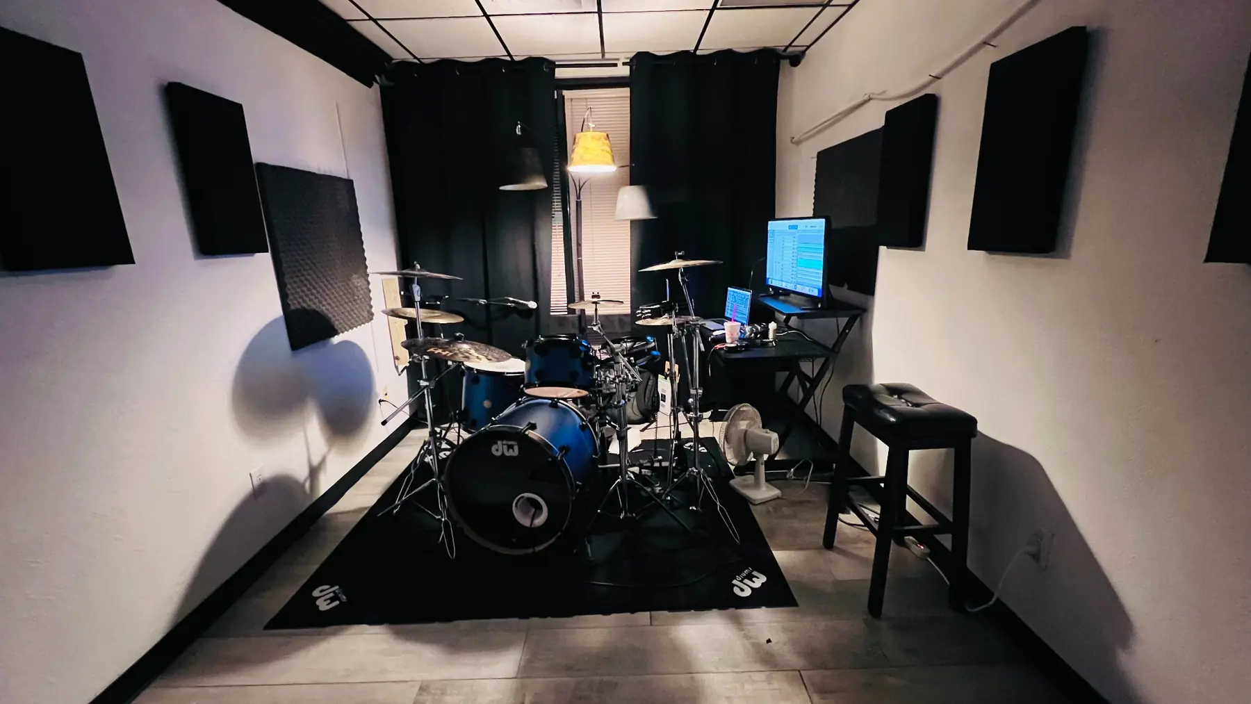 Small EMP hourly rehearsal room shown with a drum kit and computer workstation
